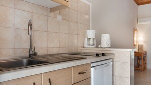 A modern kitchen with a stainless steel sink, a coffee maker, and a dishwasher.