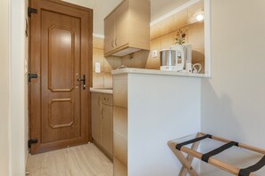 Une cuisine avec des meubles de rangement en bois, un plan de travail et un égouttoir.