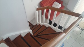 Eine Treppe mit Holzbalken und weißen Geländern.