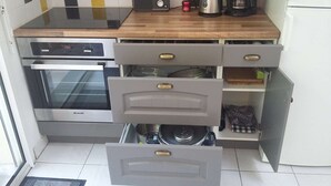 Eine Küche mit Einbauofen, Kaffeemaschine und Mikrowelle.