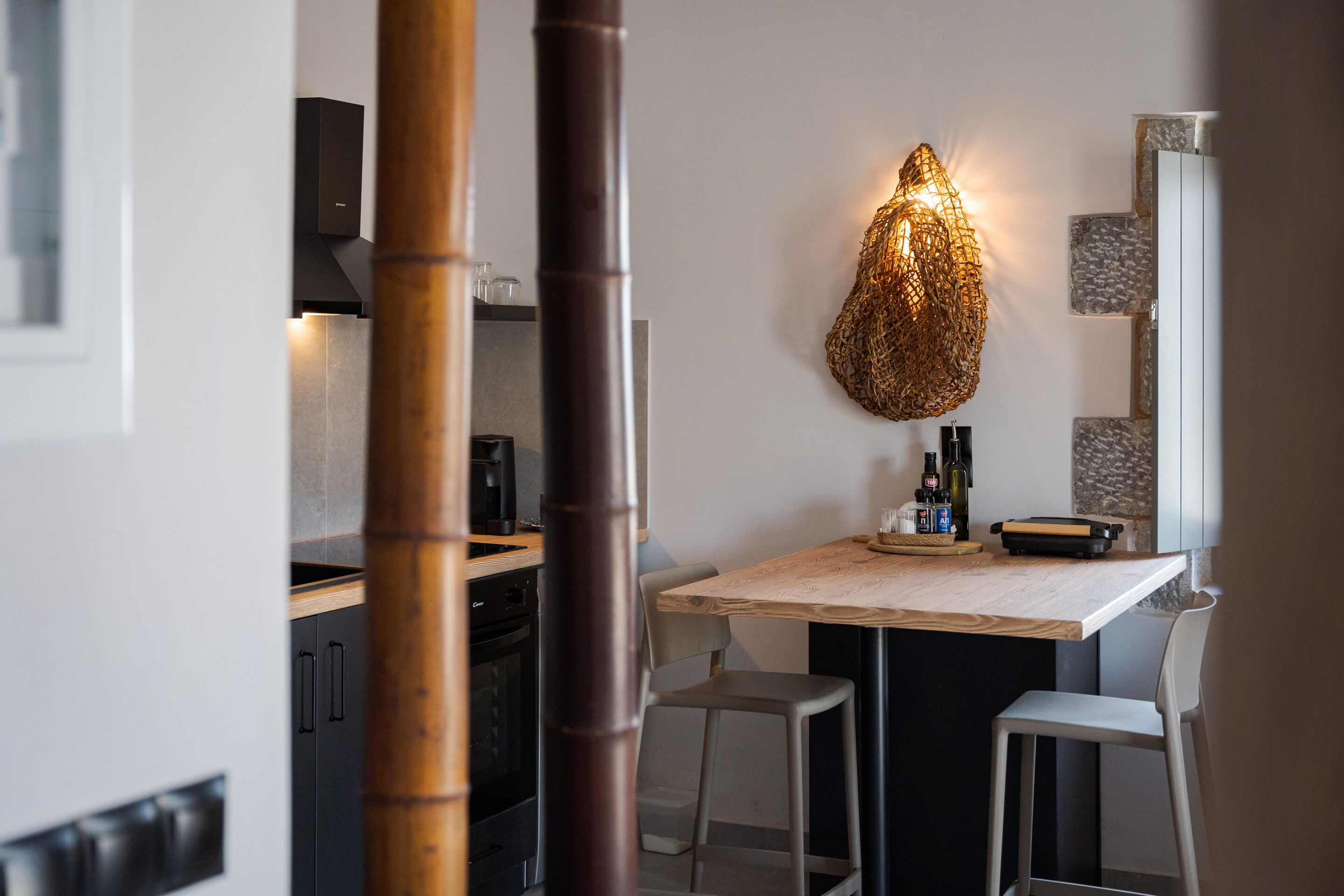Uma cozinha moderna com mesa de jantar, cadeiras e um pendente de luz exclusivo.