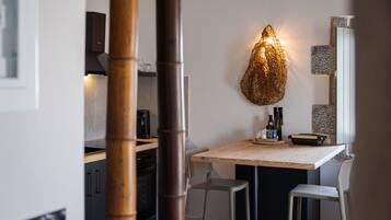 Uma cozinha moderna com mesa de jantar, cadeiras e um pendente de luz exclusivo.