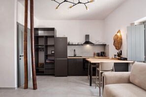 Une cuisine moderne dotée d’un réfrigérateur encastré, d’une table à manger et d’un coin salon.