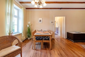 Un espace repas comprenant une table en bois, des chaises et un lustre.