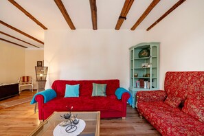 Un salon avec un canapé rouge, un meuble vert et un plafond en bois.