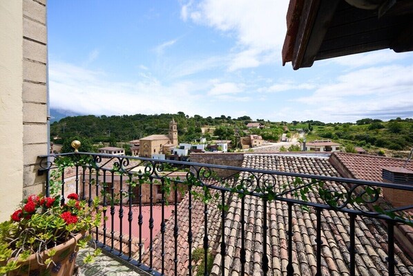 A balcony with a tiled roof, a view of a village, and a church tower. - WineEscape by Fidalsa (Villabuena de Álava / Eskuernaga)