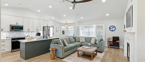 A spacious living area with a large island, a sofa, and a fireplace.