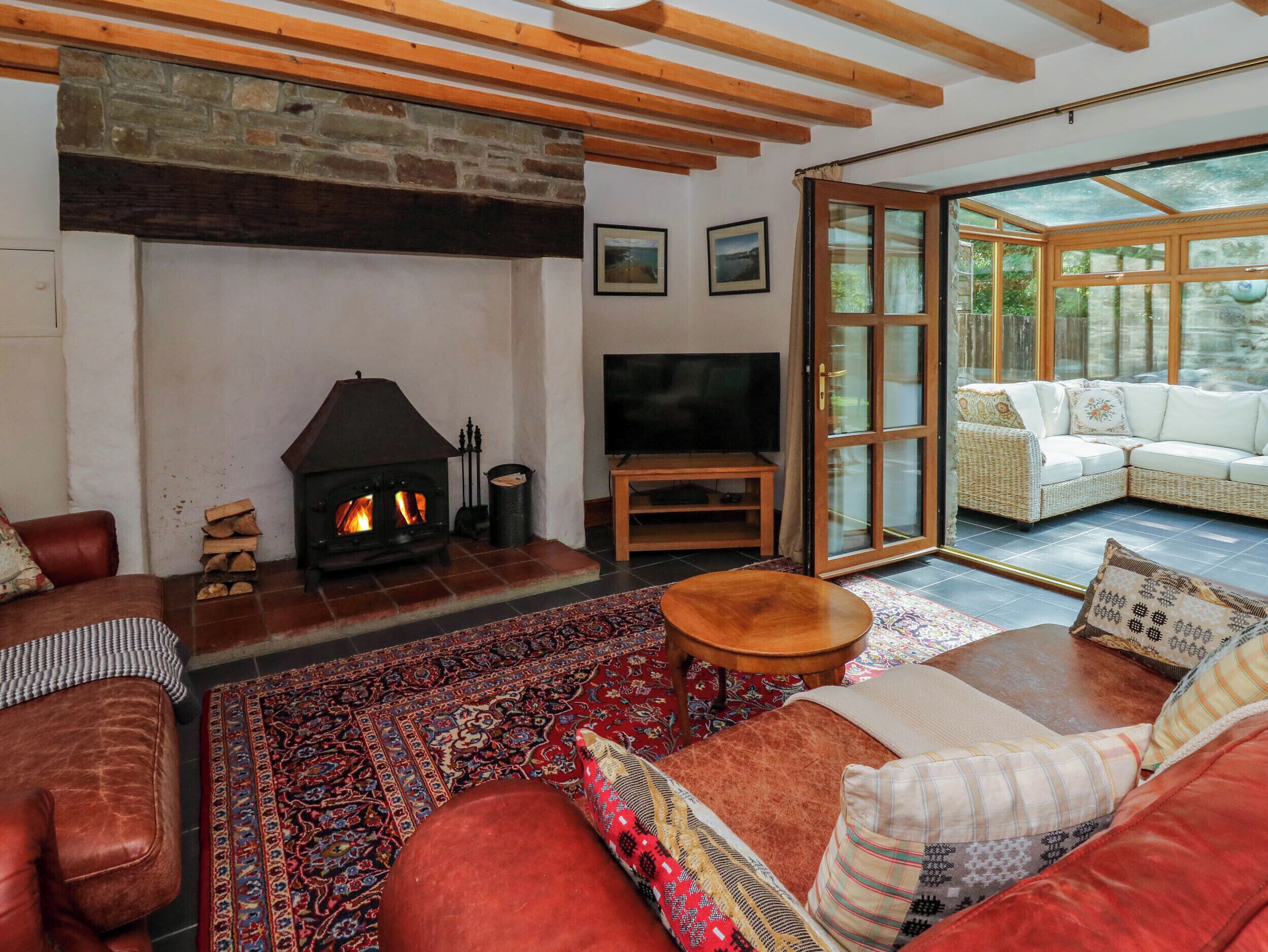 A cozy living room with a fireplace, a television, and comfortable seating.