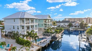 Ein Resort mit großem Pool, mehrstöckigen Gebäuden und einer Anlegestelle.