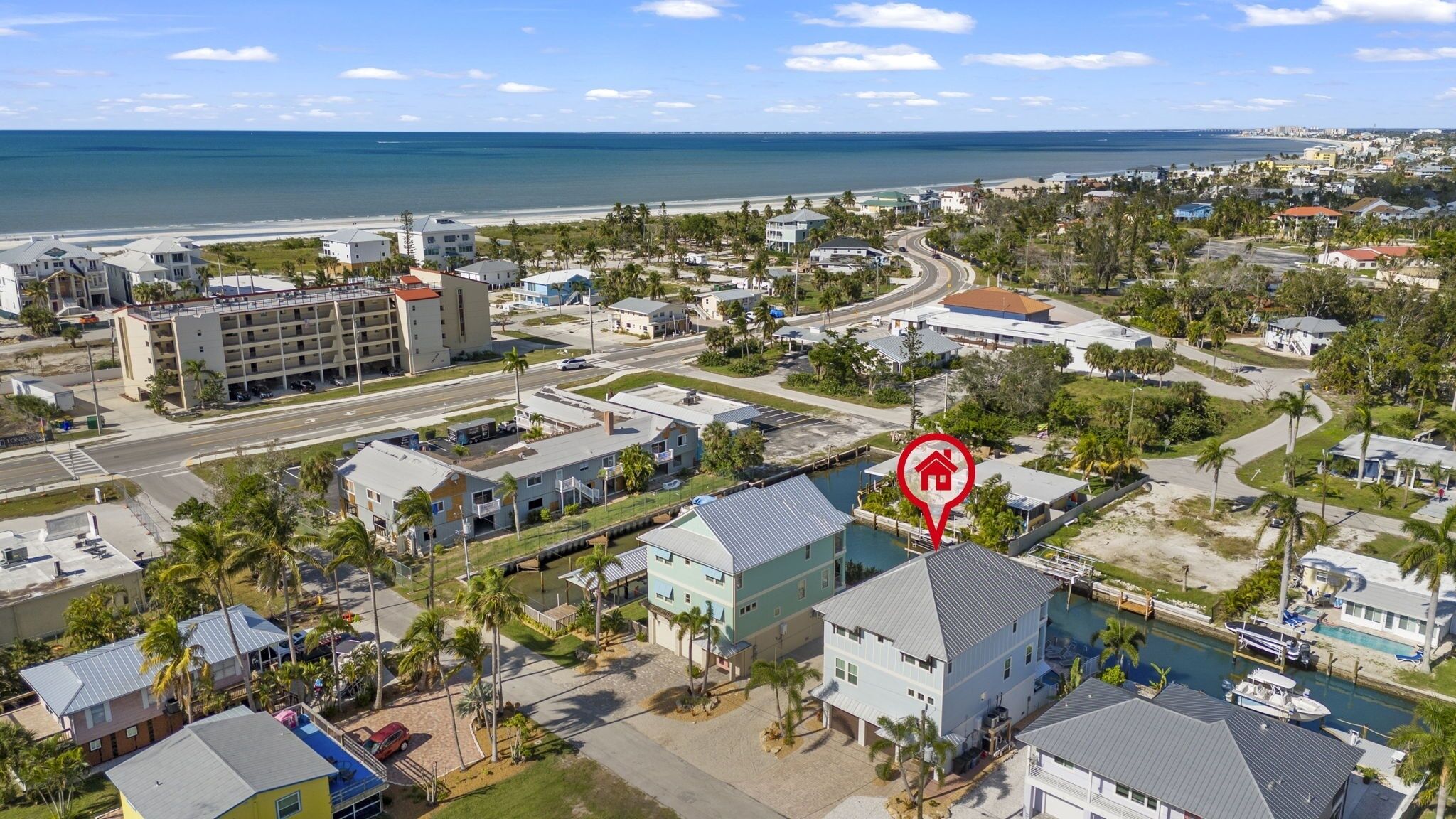An aerial view of a coastal residential area with a prominent hotel marked by a house icon.