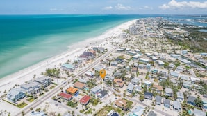 An aerial view of a coastal town with a beach, residential buildings, and a marked location. - 130 Tiki Tides: 2br W/ Outdoor Tiki Bar! 2 Bedroom Home (Fort Myers Beach)