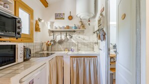 A compact kitchen with a microwave, toaster, and refrigerator.
