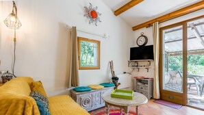 A cozy room with a bed, a table with a tray, a television, and a window with curtains.
