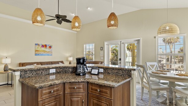 A kitchen with granite countertops, wooden cabinets, a coffee maker, and pendant lighting. - 241 Oasis Pearl: 3br Pool Home! 3 Bedroom Home (Fort Myers Beach)