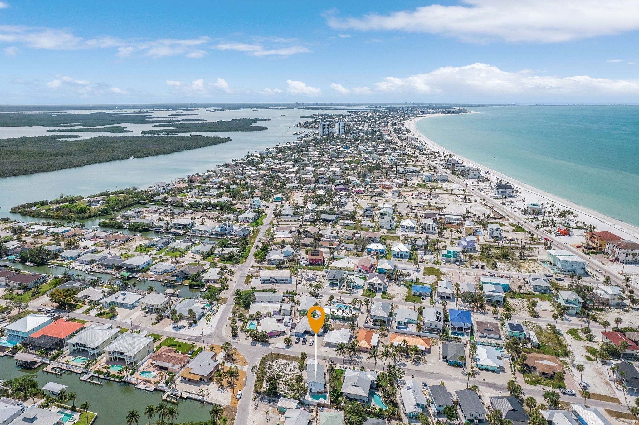 A coastal residential area with a marina, houses, and a beach.