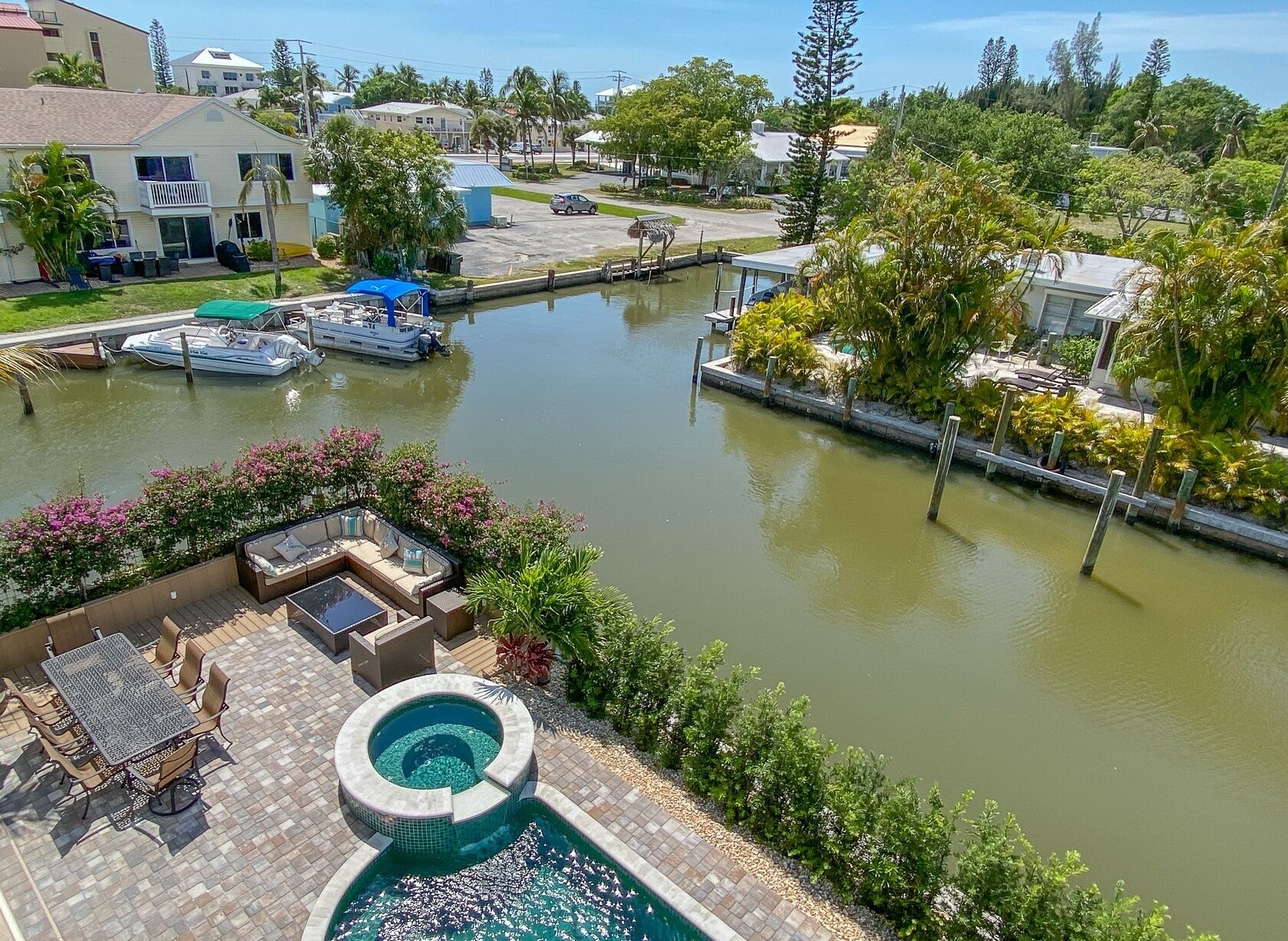 Un puerto deportivo con barcos amarrados, una piscina y un patio con mobiliario exterior.