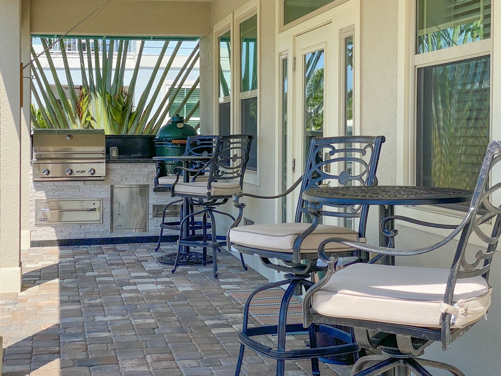 Une terrasse extérieure équipée d’un barbecue, de sièges et offrant une vue sur l’océan.