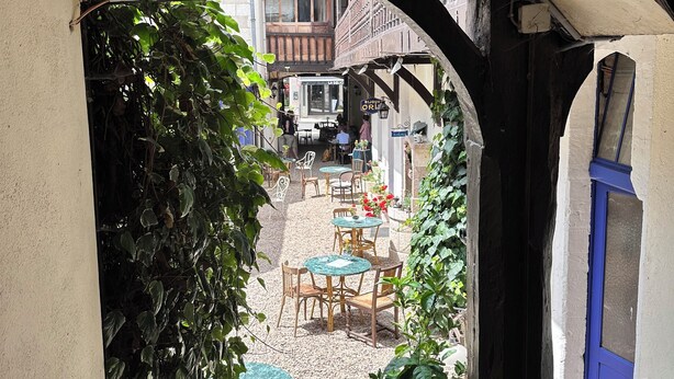 An outdoor seating area with tables and chairs, surrounded by greenery and a gravel path. - Chez Jacques-Louis (Cosne-Cours-sur-Loire)