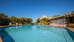 A clear blue swimming pool with lounge chairs and palm trees. - Wailea Ekolu 803 1 Bedroom Condo (Kihei)