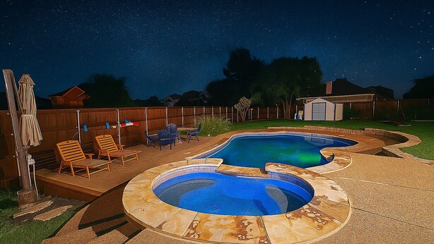 A backyard with a swimming pool, a wooden deck, and a covered seating area.