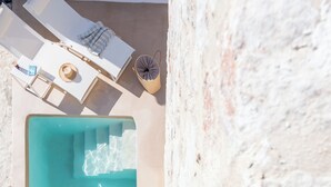 Une piscine sur le toit offrant une vue dégagée sur les environs, ainsi qu’un espace de détente avec une table et des chaises.