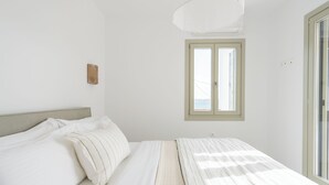 Ein Schlafzimmer mit Bett, Fenster und einer Lampe.