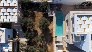 Vue aérienne d’un quartier résidentiel avec une piscine, entouré d’arbres et de bâtiments modernes.