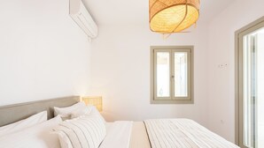 Une chambre à coucher avec un lit, une fenêtre et un climatiseur fixé au mur.