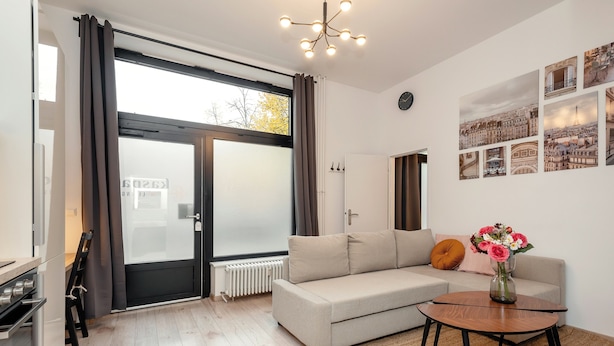 A modern living room with a sofa, a coffee table, and a view through a glass door.