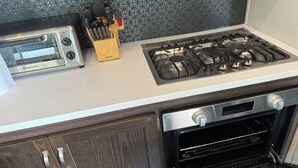 Una cocina con tostadora, estufa a gas y horno.