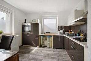 Une cuisine moderne équipée d’un four encastré, d’un four à micro-ondes et d’une fenêtre.