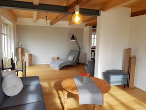 A modern living room with a sofa, a curved coffee table, a chair, and a lamp.