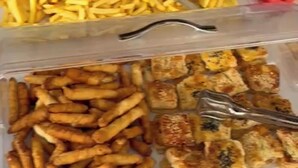 A buffet table with various food items including French fries and grilled items.