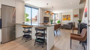 A modern kitchen with a large island, stainless steel appliances, and a dining area with a sofa and chairs. - Holiday Home '5 Minutes From The Beach' with Sea View, Wi-Fi and Air Conditioning (Fuengirola)