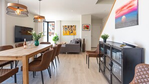 A modern living room with a dining area, a sofa, a TV, and a painting on the wall. - Holiday Home '5 Minutes From The Beach' with Sea View, Wi-Fi and Air Conditioning (Fuengirola)