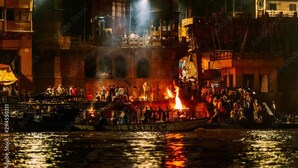 Un bote con gente, rodeado de edificios y un incendio.