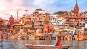 Un río con barcos y una ciudad densamente construida con arquitectura histórica.