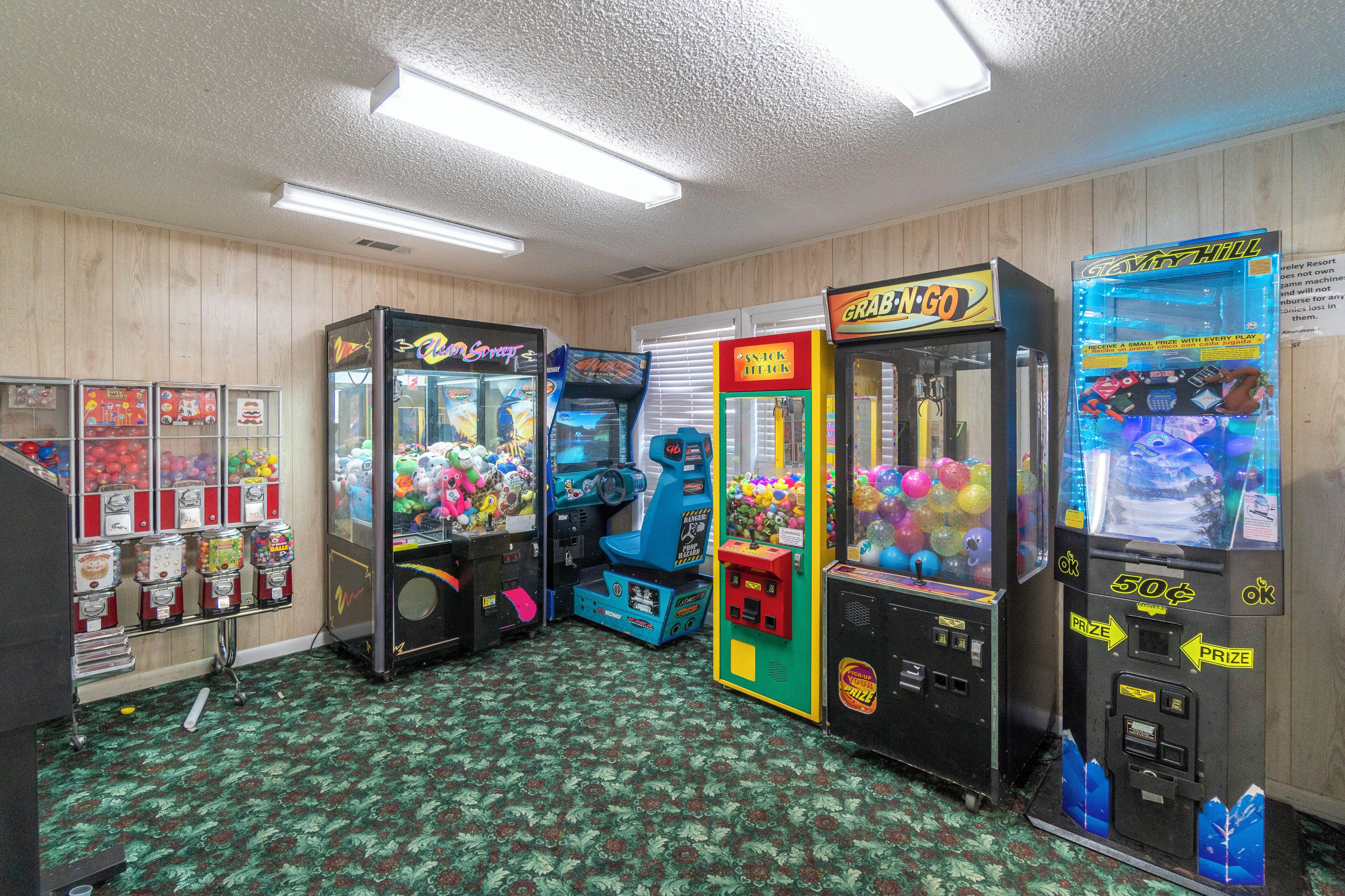 Quarto com jogos de fliperama, máquina de venda automática e bar de petiscos.