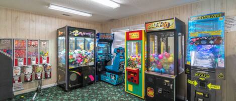 Quarto com jogos de fliperama, máquina de venda automática e bar de petiscos.