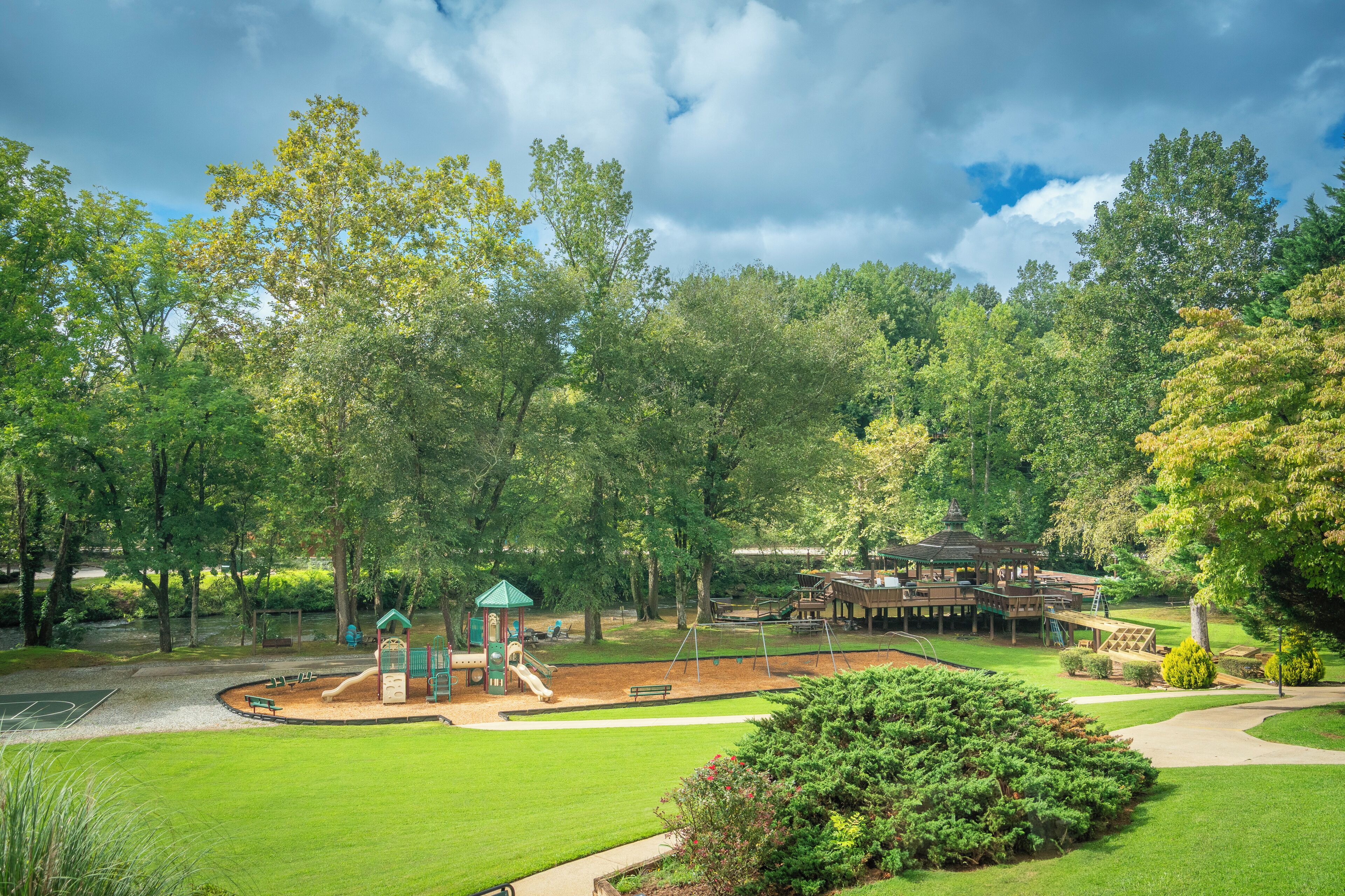 Ein Park mit Spielplätzen, einer Laube und einer hölzernen Konstruktion.