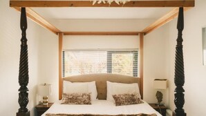 A bedroom with a four-poster bed, wooden headboard, and a window with blinds. - 1997 Stays Galway (Galway)