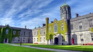 A historic building with ivy-covered walls, a prominent tower, and a well-maintained lawn. - 1997 Stays Galway (Galway)