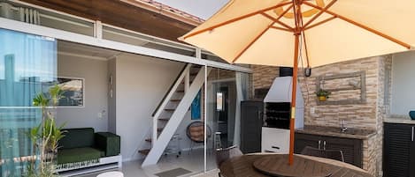 An outdoor patio with a table, chairs, and a large umbrella.