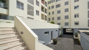 A multi-story residential building with a central courtyard, a staircase leading to the upper floors, and a gated entrance. - Close to all facilities | Madalena Living Apt (Funchal)