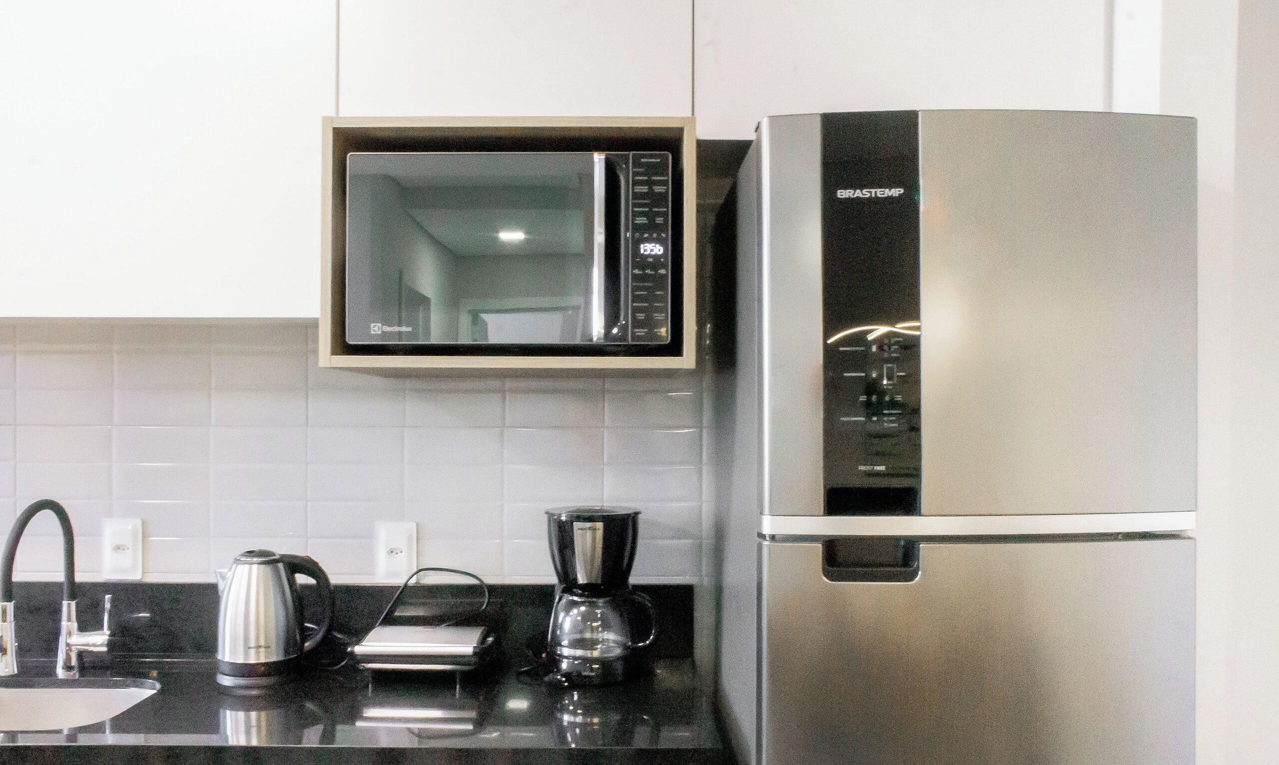 Una cocina equipada con microondas, cafetera y refrigerador.