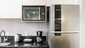 Eine Küche mit Mikrowelle, Kaffeemaschine und Kühlschrank.