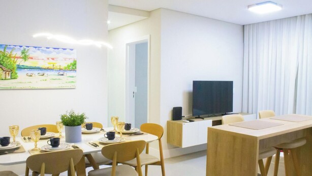 Ein modernes Wohnzimmer mit Essbereich, einem Flachbildfernseher und einem Gemälde an der Wand.