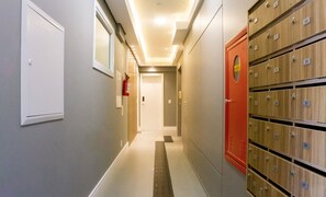 A hotel corridor with lockers on the right and a fire extinguisher on the left.