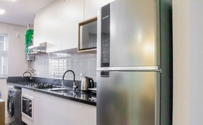 Una cocina moderna con electrodomésticos de acero inoxidable, horno empotrado y microondas.