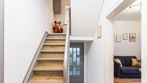 Eine Treppe mit Holzbodenstufen führt zu einer Tür mit Milchglasscheibe.